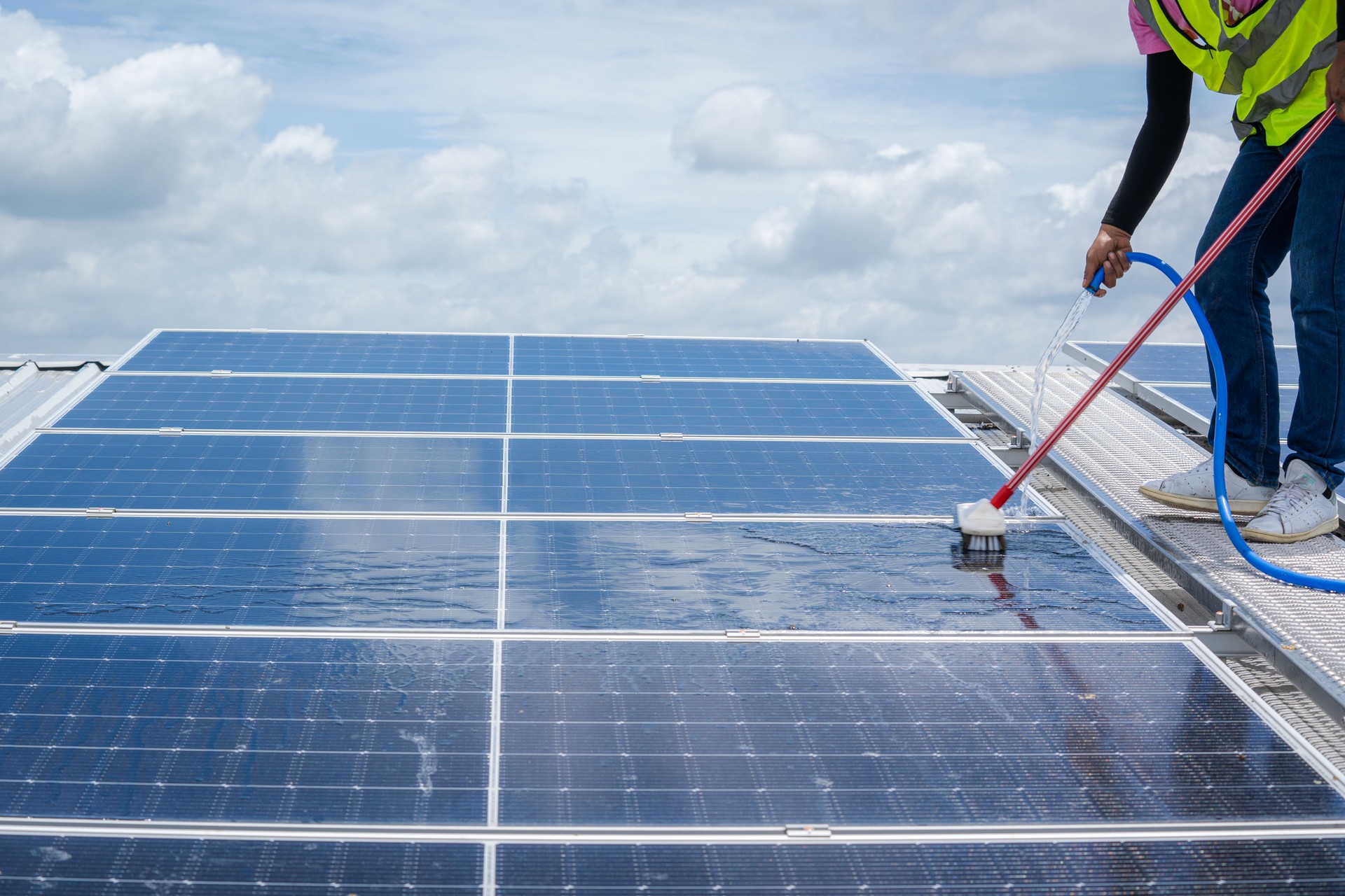 Professional worker cleaning solar panels.